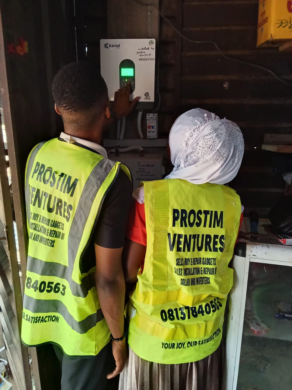 Prostim team members beside an installed inverter